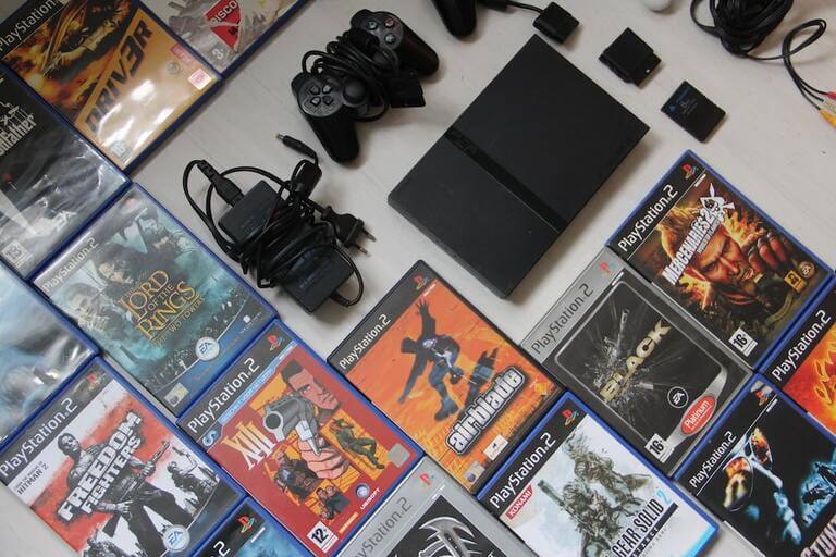 The PS2 Slim and a collection of games. (Image Source: Denise Jans on Unsplash.com)